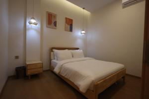 a bedroom with a bed with white sheets and pillows at Casabella 102 BCS A2 Grand Batam Penuin Wet Market in Nagoya