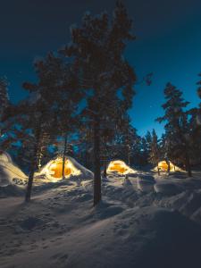 a group of tents in the snow at night at Eventyrhyttene i Jotunheimen in Stuttgongfossen