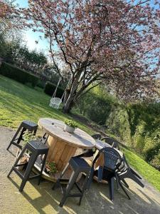 einen Picknicktisch mit vier Stühlen und einem Baum in der Unterkunft Maison du Bonheur in Trélon