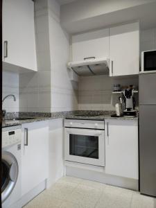 La cuisine est équipée de placards blancs et d'un lave-vaisselle. dans l'établissement Suite Ribadesella VUT2191AS, à Ribadesella