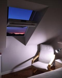a room with a bed and a chair with a window at Suite Ribadesella VUT2191AS in Ribadesella