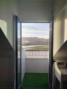 uma porta aberta para uma varanda com um piso verde em Suite Ribadesella VUT2191AS em Ribadesella