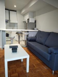 uma sala de estar com um sofá azul e uma mesa branca em Suite Ribadesella VUT2191AS em Ribadesella