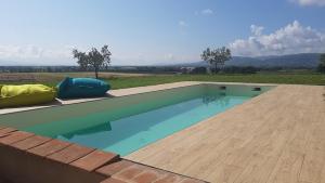 a swimming pool on a patio with a wooden deck at Casale Ziarelli in Brufa