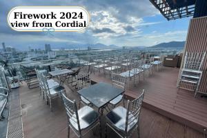 a patio with tables and chairs on a balcony at Cordial Hotel and Spa in Da Nang