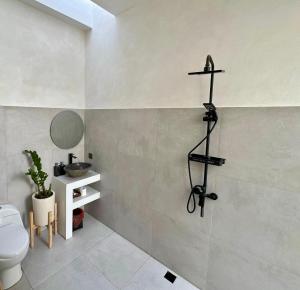 uma casa de banho com WC e uma cruz na parede em Trendy 1-Bedroom-Villa 'Lala' in Uluwatu em Jimbaran