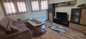 a living room with a couch and a flat screen tv at Paradise Apartment - Breathtaking View in Veliko Tŭrnovo