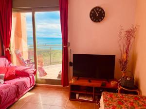 - un salon avec une télévision et une vue sur l'océan dans l'établissement Precioso ático en la Sierra de Irta, à Alcossebre
