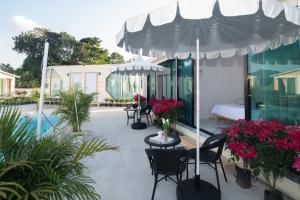 d'une terrasse avec des tables, des chaises et un parasol. dans l'établissement บ้านสายน้ำ วิลล่า, à Chiang Khan