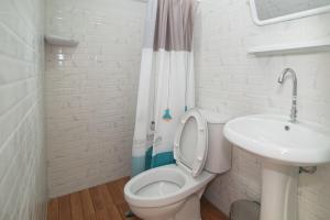 a white bathroom with a toilet and a sink at บ้านสายน้ำ วิลล่า in Chiang Khan