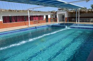 una grande piscina con acqua blu di fronte a un edificio di منتجع ريف خزيمة - الياسمين a Medina