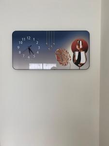 a clock hanging on a wall with a clock and a chair at Studio Apartment in Phuket Town
