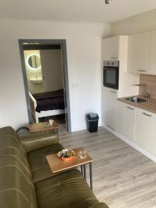 a living room with a couch and a kitchen at Studio Lodo in Middelburg