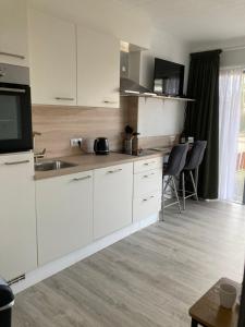 a kitchen with white cabinets and a sink at Studio Lodo in Middelburg