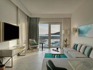 a living room with a couch and a television at The Chedi Luštica Bay in Tivat