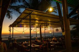 a restaurant with a view of the beach at sunset at Jardim a Mar in Agonda