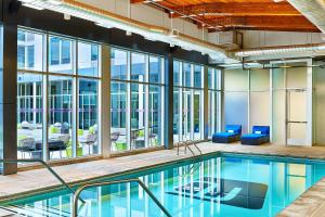 an indoor pool in a building with windows at Aloft Denver Airport at Gateway Park in Aurora