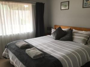 a bedroom with a bed with two towels on it at River Heights in Taupo