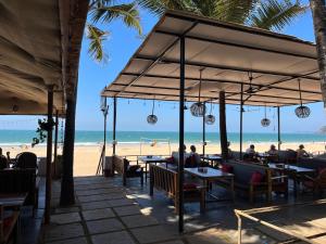 a restaurant on the beach with people sitting at tables at Jardim a Mar in Agonda