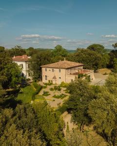 Luftblick auf ein Haus und Bäume in der Unterkunft Villa Cosmiana suites in Peccioli