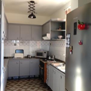 a kitchen with white cabinets and a stainless steel refrigerator at Apartamentos cercanos playa 1 in Puentedeume +7 photos