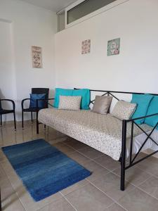 - un canapé dans une pièce avec des chaises et un tapis dans l'établissement Artemisia Apartment, à Koskinou