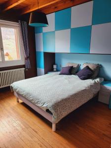 a bedroom with a bed with a blue and white wall at Les Balcons du Mont-Blanc : Appartement centre village in Cordon