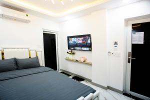 a bedroom with a bed and a tv on the wall at Le Vu Hotel in Ho Chi Minh City