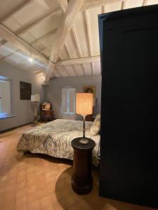 ein Schlafzimmer mit einem Bett und einer Lampe auf einem Tisch in der Unterkunft Villa Cosmiana suites in Peccioli