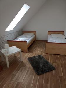 two beds in a room with a rug and a table at Ferienwohnung Liane in Federow