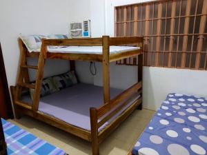 a bunk bed in a dorm room with a bunk bedutenewayangering at Estrelle Orange House - Backpackers Hub in Puerto Princesa City