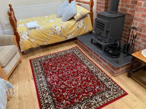 a bedroom with a fireplace with a bed and a rug at Oldcotes Studio. in Firbeck