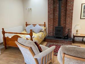 a living room with a bed and chairs and a fireplace at Oldcotes Studio. in Firbeck