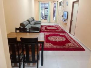 a living room with a table and a couch at Aqiza Home Kuala Krai in Kuala Kerai