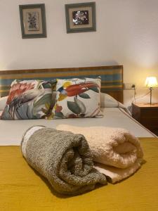 a towel laying on top of a bed with pillows at Casa Celia in Miranda del Rey