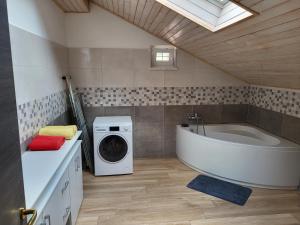a bathroom with a tub and a washing machine at apartma jermol in Most na Soči +7 photos