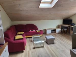 a living room with a red couch in a attic at apartma jermol in Most na Soči