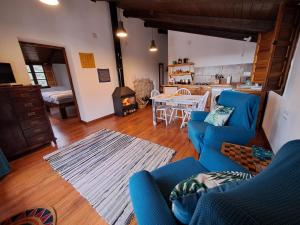 sala de estar con sofás azules y cocina en Cortijo Berruguilla, en Lojilla
