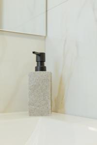 un dispenser di sapone su una mensola in bagno di APPARTAMENTO ACACIA a Imola