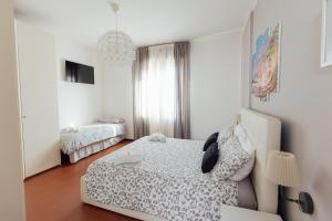 a white bedroom with a bed and a window at APPARTAMENTO ACACIA in Imola