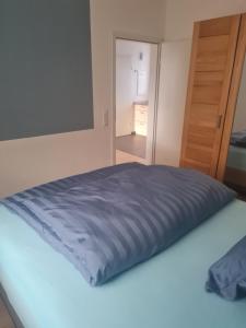 a bed with a blue blanket on top of it at Anides in Dillingen an der Donau