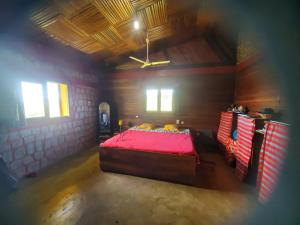 ein Schlafzimmer mit einem roten Bett in einem Zimmer in der Unterkunft villa vanille in Tôlagnaro