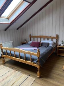 ein Schlafzimmer mit einem Holzbett im Dachgeschoss in der Unterkunft Magyar Lovasvendégház in Szilvásvárad