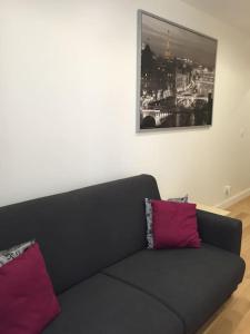 a black couch with two pink pillows in a room at Paris 5e Quartier Latin 2 pieces en Bail Mobilité in Paris