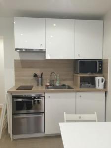 a kitchen with white cabinets and a stainless steel oven at Paris 5e Quartier Latin 2 pieces en Bail Mobilité in Paris