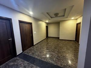 une chambre vide avec deux portes et un sol en marbre dans l'établissement Hotel Keptown Lite, à Jaipur