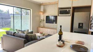 ein Wohnzimmer mit einem Tisch und einer Flasche Wein in der Unterkunft Executive Suites Brackenhurst in Alberton