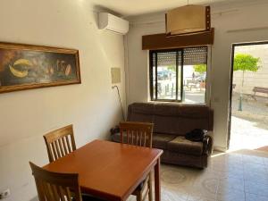 ein Esszimmer mit einem Tisch und einem Sofa in der Unterkunft casa Sao bras Alportel Miguel in São Brás de Alportel