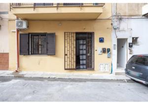 un edificio con una porta e una macchina parcheggiata di fronte di Case Billeci Casa Verde a Palermo
