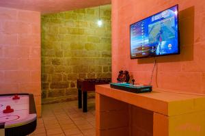En TV eller et underholdningssystem på Grand Gozo Farmhouse with Games Room & Pool